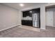 Basement kitchenette featuring dark cabinets, granite countertops, stainless steel fridge, and modern finishes at 15540 Starflower Dr, Westfield, IN 46074