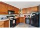 L-shaped kitchen with wood cabinets and black appliances at 1650 Stout St, Martinsville, IN 46151