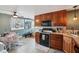 Bright kitchen with wood cabinets, black appliances, and tile floor at 1650 Stout St, Martinsville, IN 46151