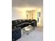 Inviting living room featuring comfortable black leather seating, neutral carpeting, and a glass-top coffee table at 2322 Bainbridge Rd, Greenwood, IN 46143