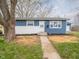 Close-up of the front exterior featuring blue and white facade, freshly planted landscaping, and concrete walkway at 2814 S Randolph St, Indianapolis, IN 46203