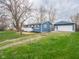 Charming blue and white home with detached garage, lush lawn, and freshly landscaped mulch areas at 2814 S Randolph St, Indianapolis, IN 46203
