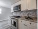 Modern kitchen featuring stainless steel appliances, gray backsplash, and white cabinets at 2814 S Randolph St, Indianapolis, IN 46203