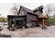Beautiful modern farmhouse with dark siding, a stone foundation, wood porch accents, and a large paved driveway at 301 Lowry St, Jamestown, IN 46147