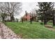 Scenic view of a classic red brick home framed by a black fence, and a lush green lawn at 301 Lowry St, Jamestown, IN 46147