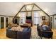 Spacious living room with vaulted ceilings, wooden beams, plush couches, and large windows providing ample natural light at 301 Lowry St, Jamestown, IN 46147