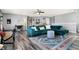 Open living area with a teal sectional sofa and wood-look floors at 3174 Hemlock St, Whiteland, IN 46184