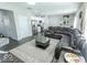 Open-concept living room and kitchen with dark leather sectional sofa and stainless steel appliances at 419 Bluestem Ln, Whiteland, IN 46184