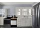 Kitchen featuring gray floors, stainless steel appliances, white cabinetry, and a window over the sink at 5210 E Pleasant Run Parkway North Dr, Indianapolis, IN 46219