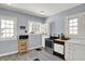 Cozy kitchen featuring grey floors, white cabinetry, stainless steel appliances, and plenty of natural light at 5210 E Pleasant Run Parkway North Dr, Indianapolis, IN 46219