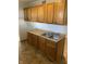 Neat kitchen featuring wood cabinets, double sink, and tiled floor at 5778 E 30Th St, Indianapolis, IN 46218