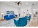 Spacious living room with hardwood floors, a blue velvet sofa, and a ceiling fan at 5943 Crooked Creek Dr, Indianapolis, IN 46228