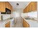 Simple kitchen with wood cabinets, white appliances, and double sink at 7952 Sunset Cove Dr, Indianapolis, IN 46236