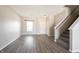 Living room with gray vinyl flooring, white walls, and staircase at 9286 W Quarter Moon Dr, Pendleton, IN 46064