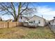 Backyard with a wooden deck, fence, grass, and a large tree at 1028 Albany St, Indianapolis, IN 46203