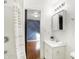 White bathroom featuring a vanity and mirror, complemented by a shower with a patterned curtain, connecting to a stylish bedroom at 1028 Albany St, Indianapolis, IN 46203