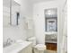 Bright bathroom with a view into the bedroom, featuring a classic vanity, toilet, and a shower-tub combo at 1028 Albany St, Indianapolis, IN 46203