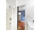 Bathroom featuring bright vanity and shower with rod, with connecting door opening to a stylish blue bedroom at 1028 Albany St, Indianapolis, IN 46203