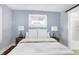 Calming bedroom with light blue walls, features matching lamps and a bright window at 1028 Albany St, Indianapolis, IN 46203