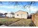 View of detached garage with siding, door, small window, and a small fenced in yard at 1028 Albany St, Indianapolis, IN 46203