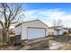 View of detached garage with a white garage door, vinyl siding, and fenced yard at 1028 Albany St, Indianapolis, IN 46203