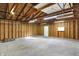 Spacious garage featuring concrete floor, wood stud walls, overhead lighting and garage door at 1028 Albany St, Indianapolis, IN 46203