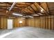 Spacious garage featuring concrete floor, wood stud walls, overhead lighting and garage door at 1028 Albany St, Indianapolis, IN 46203