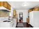 Charming kitchen with wooden cabinets, white appliances, and an open layout with view to living room at 1028 Albany St, Indianapolis, IN 46203