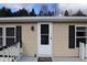 Tan mobile home exterior with white door and black shutters at 12160 W Baker Hollow Rd, Columbus, IN 47201