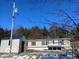 Tan mobile home with deck and storage shed, winter setting with trees at 12160 W Baker Hollow Rd, Columbus, IN 47201