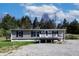 Charming single-story home featuring a front deck and gravel driveway at 12160 W Baker Hollow Rd, Columbus, IN 47201