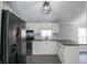 Modern kitchen with white cabinets, granite countertops and black appliances at 12160 W Baker Hollow Rd, Columbus, IN 47201