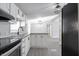 Open kitchen with white cabinets, granite counters & black appliances at 12160 W Baker Hollow Rd, Columbus, IN 47201