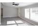 Bright living room with gray walls, wood-look floors, and ceiling fan at 12160 W Baker Hollow Rd, Columbus, IN 47201