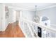 Bright hallway featuring hardwood floors, decorative lighting, and staircase to the lower level at 1535 Cricklewood Way, Zionsville, IN 46077