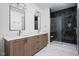 Modern bathroom with double vanity, marble floors, and a glass-enclosed shower featuring dark tile and a built-in bench at 1674 Solebar Way, Westfield, IN 46074