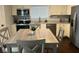 Eat-in kitchen featuring stainless steel appliances, white cabinetry, and hardwood flooring at 18 S Franklin St, Greenfield, IN 46140
