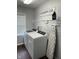 Functional laundry room with modern washer, dryer, ironing board and convenient shelving at 18 S Franklin St, Greenfield, IN 46140