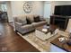 Comfortable living room featuring hardwood floors, a large sofa, fireplace, and decorative accents at 18 S Franklin St, Greenfield, IN 46140