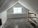 Attic bedroom with window and unfinished floors at 2033 Carrollton Ave, Indianapolis, IN 46202