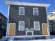 Rear view of a duplex, highlighting gray siding and two yellow doors at 2033 Carrollton Ave, Indianapolis, IN 46202