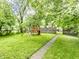 Fenced backyard with lush green grass, sidewalk and play structure at 361 S Spencer Ave, Indianapolis, IN 46219