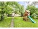 A backyard with a playground, lush green grass, and a slide at 361 S Spencer Ave, Indianapolis, IN 46219