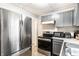 A kitchen features stainless steel appliances and gray cabinets at 361 S Spencer Ave, Indianapolis, IN 46219
