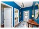 Bright blue entryway with hardwood floors, a wooden table, and a view into the living area at 502 Elnora Ln, Westfield, IN 46074