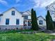 Two-story white brick house with stone accents, landscaping, and a large front porch at 5465 S State Road 75, Jamestown, IN 46147