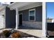 Covered front porch with stone accents and a black front door at 7226 Griffon Ln, Camby, IN 46113