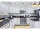 Modern kitchen with white cabinets, black countertops, and stainless steel appliances at 8043 Garden Ridge Rd, Indianapolis, IN 46237