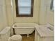 Bathroom with a toilet, sink, and clawfoot tub, ready for renovation at 817 N Linwood Ave, Indianapolis, IN 46201
