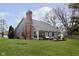 Expansive backyard featuring a brick chimney, wooden deck, and ample green space at 8198 Wade Hill Ct, Indianapolis, IN 46256